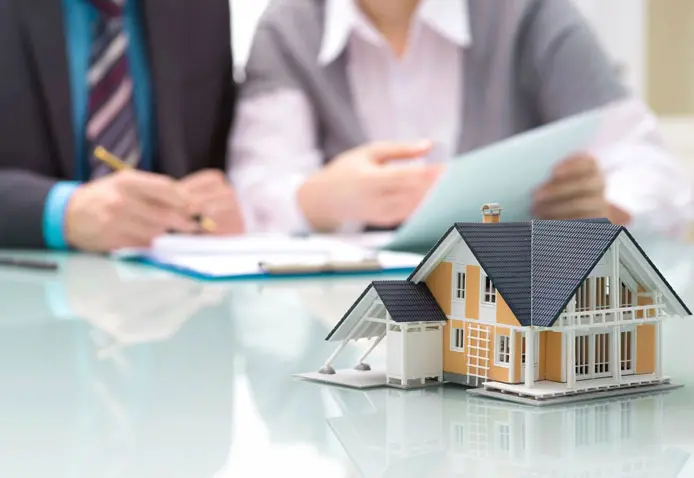 A couple of people sitting at a table with some houses.